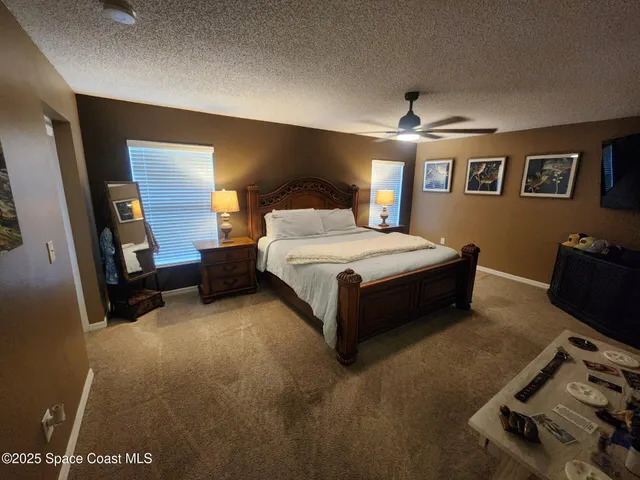 a spacious bedroom with a bed and a lamp