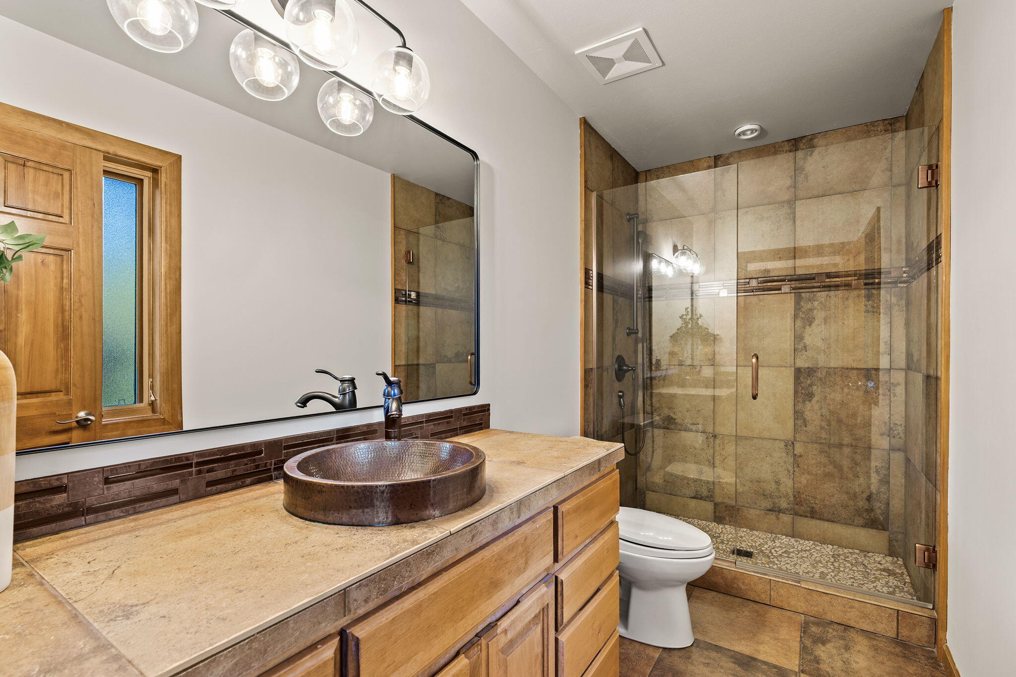 60766 Golf Village Loop Bend, OR 97702 - Photo 14 of 63 a bathroom with a sink a toilet a mirror and shower