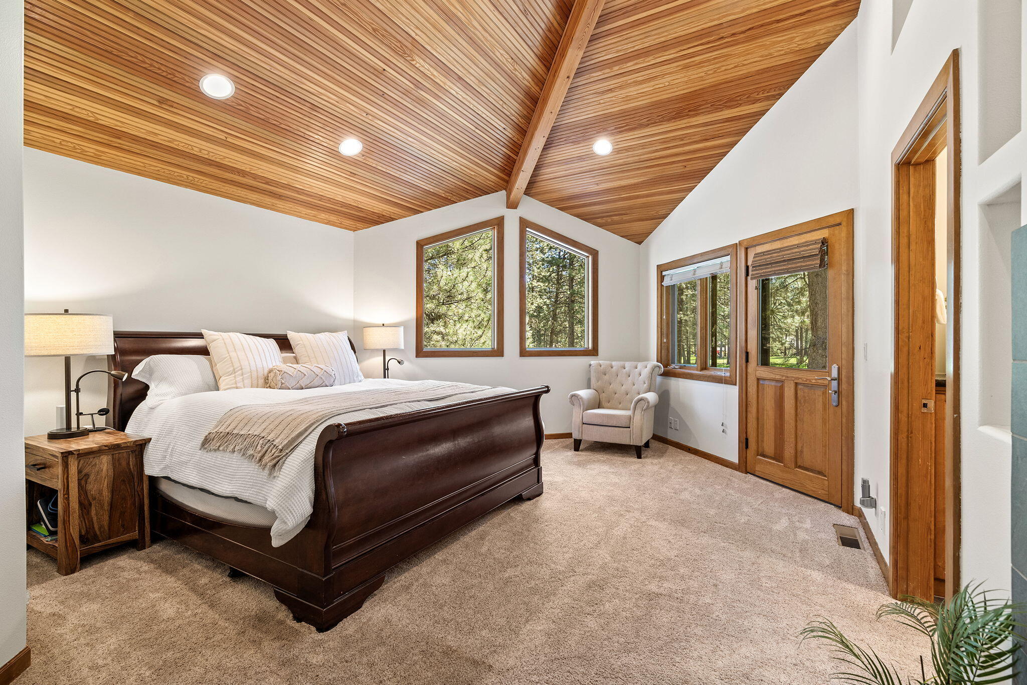 60766 Golf Village Loop Bend, OR 97702 - Photo 23 of 63 a spacious bedroom with a bed and a chandelier