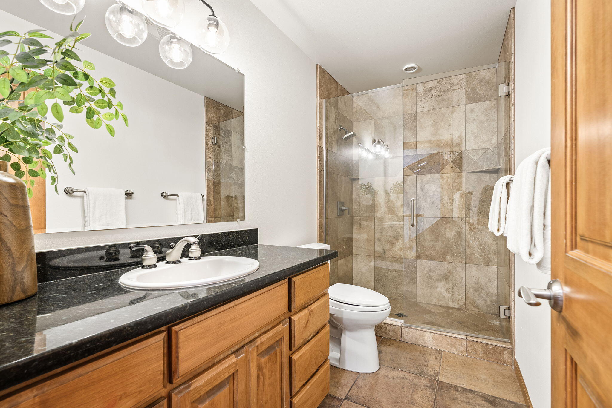 60766 Golf Village Loop Bend, OR 97702 - Photo 32 of 63 a bathroom with a granite countertop sink a toilet a mirror and shower