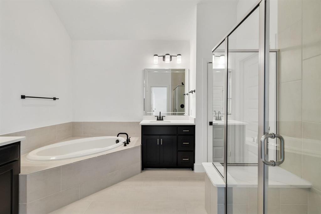 9303 Easy Street Rowlett, TX 75088 - Photo 27 of 33 a spacious bathroom with a tub shower and mirror