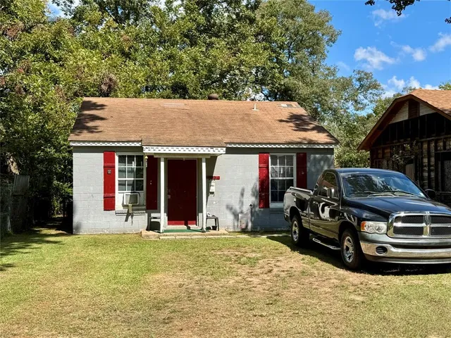 a view of a house with large windows and a lawn chair