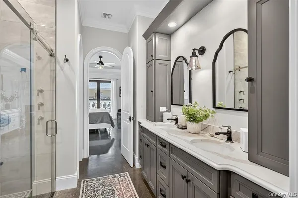 a spacious bathroom with a granite countertop sink a mirror a vanity and a shower