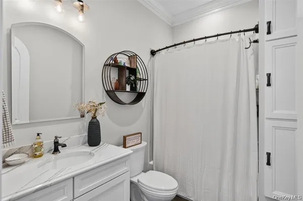 a bathroom with a sink vanity mirror and toilet