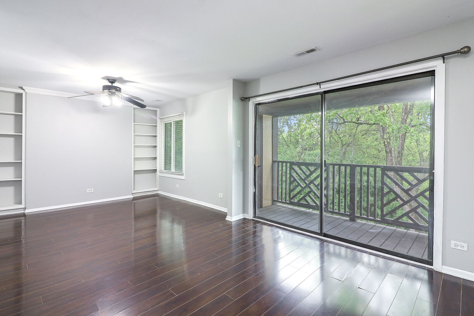 1782 Gloucester Court, Unit B Wheaton, IL 60189 - Photo 3 of 16 a view of an empty room with wooden floor and a window