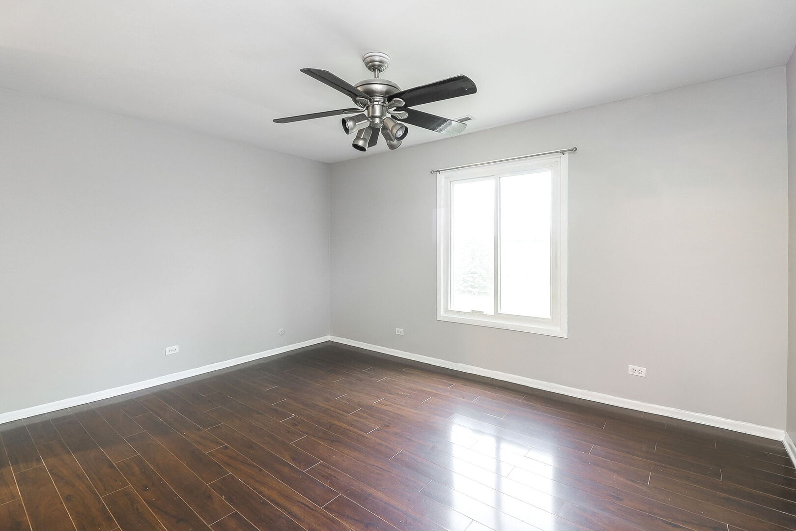 1782 Gloucester Court, Unit B Wheaton, IL 60189 - Photo 8 of 16 an empty room with wooden floor windows and fan