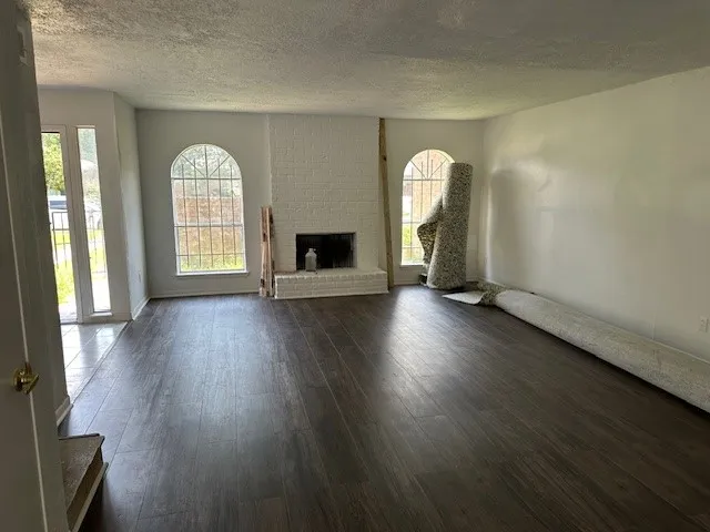 a view of a livingroom with wooden floor and a large window