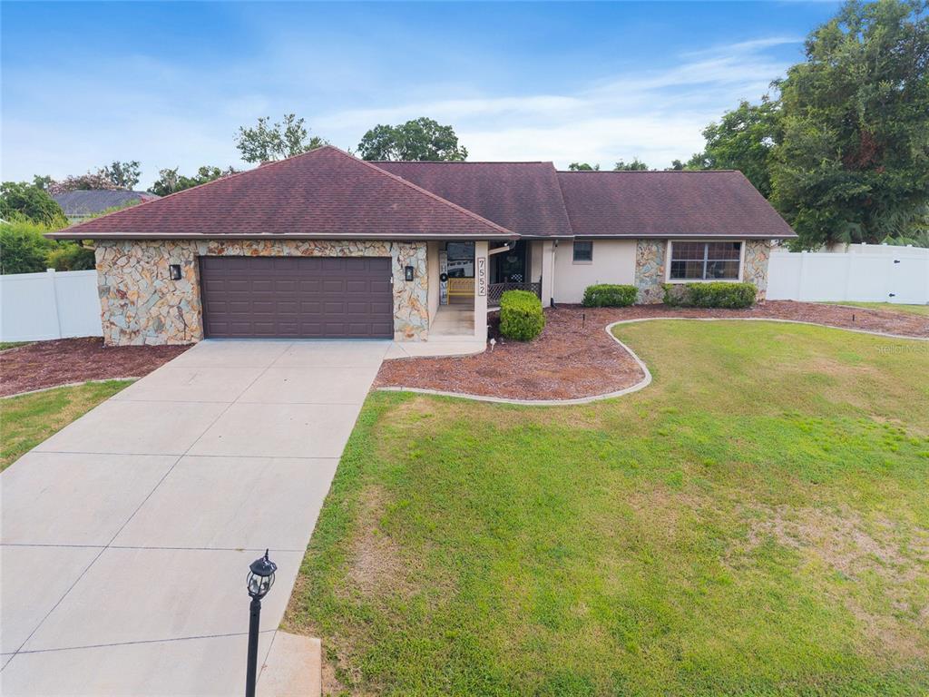 7552 Southwest 102nd Loop Ocala, FL 34476 - Photo 1 of 1 a front view of a house with yard and garage