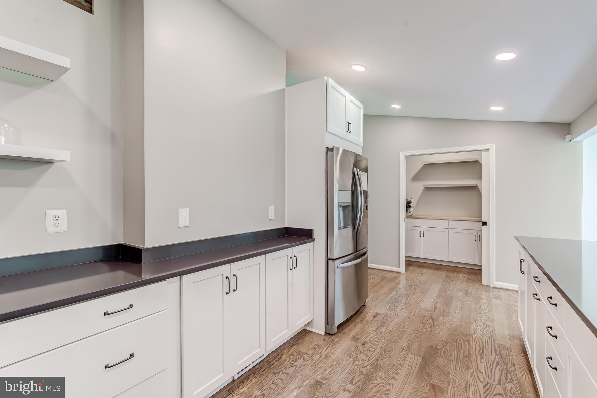 11926 Appling Valley Road Fairfax, VA 22030 - Photo 25 of 60 a kitchen with granite countertop a refrigerator a sink and wooden floor