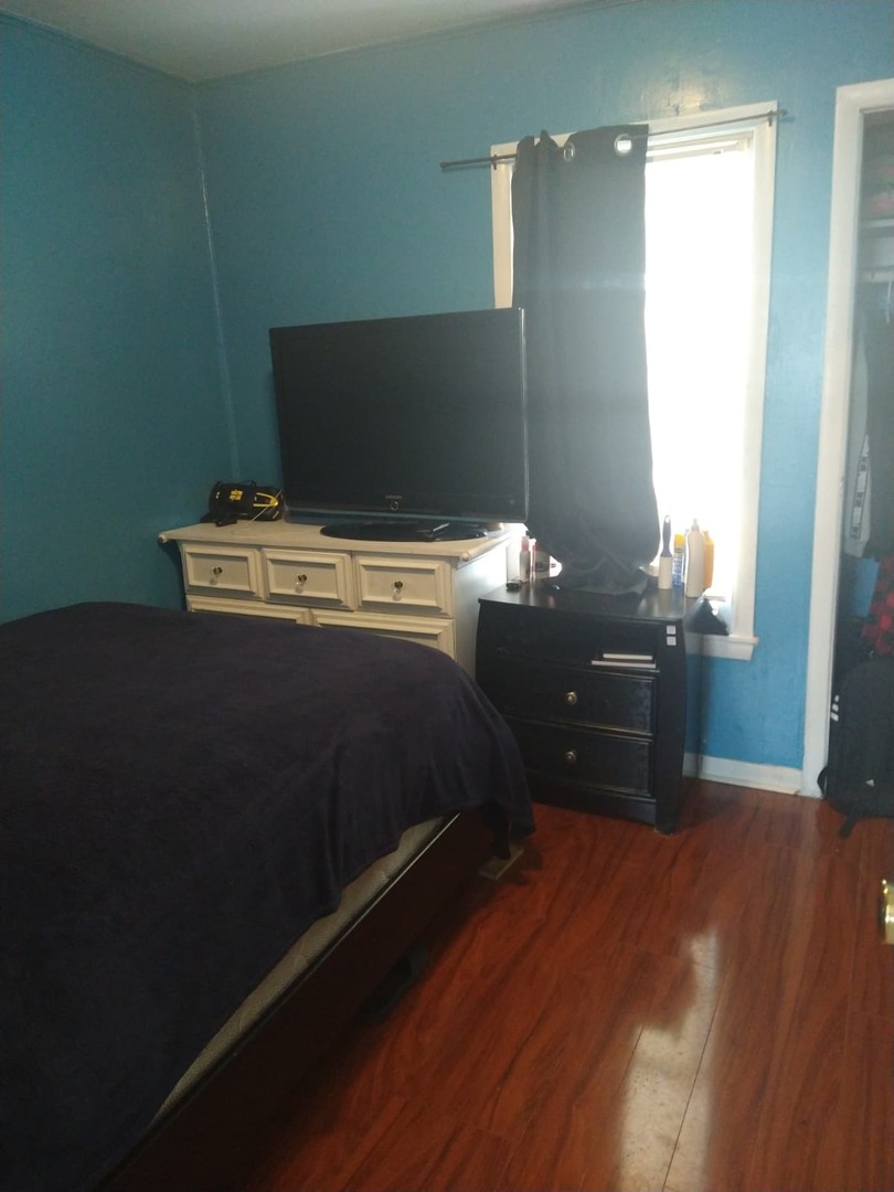 1917 Honore Avenue North Chicago, IL 60064 - Photo 13 of 27 a bed sitting in a bedroom next to a window