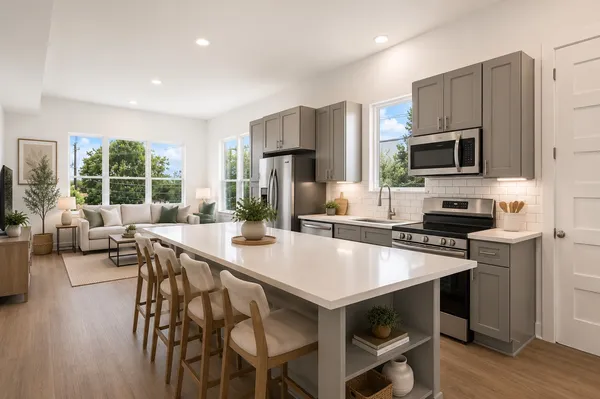 a kitchen with stainless steel appliances a stove a sink a microwave a refrigerator and cabinets