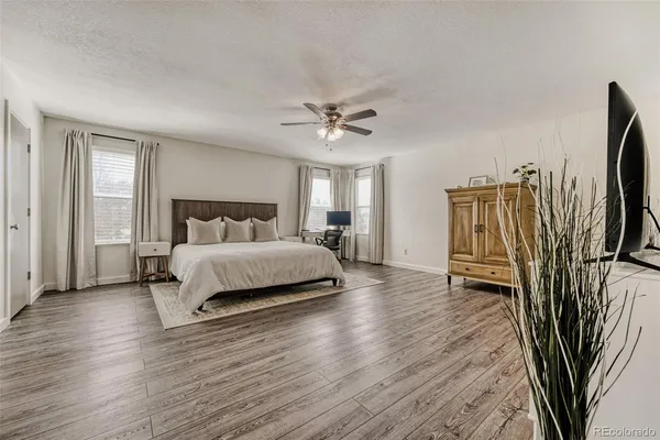 a bedroom with a bed and a walk in closet with wooden floor