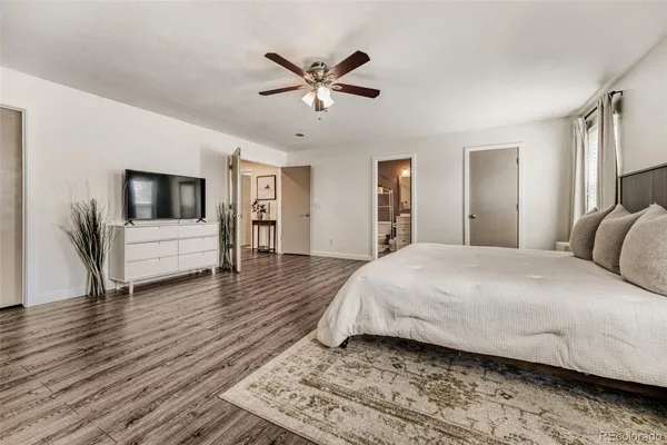 a spacious bedroom with a bed and a ceiling fan