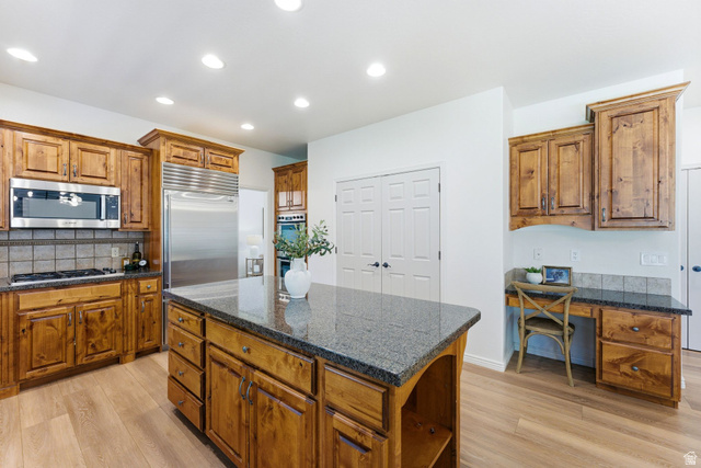 1712 Somerset Ridge Drive Draper, UT 84020 - Photo 21 of 76 Kitchen featuring a large island with a stone countertop, wood-finish flooring, stainless steel appliances, recessed lighting, and ample wood cabinetry