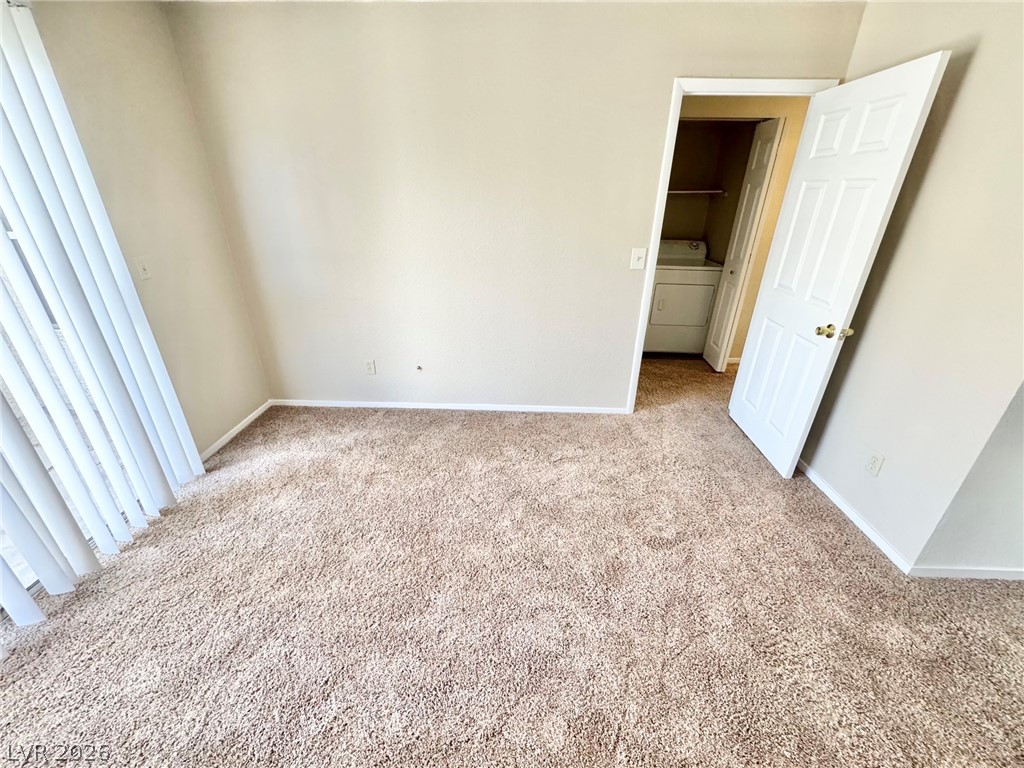 6250 West Flamingo Road, Unit 109 Las Vegas, NV 89103 - Photo 14 of 18 A well-lit room offers cozy carpeted flooring and convenient laundry amenities.