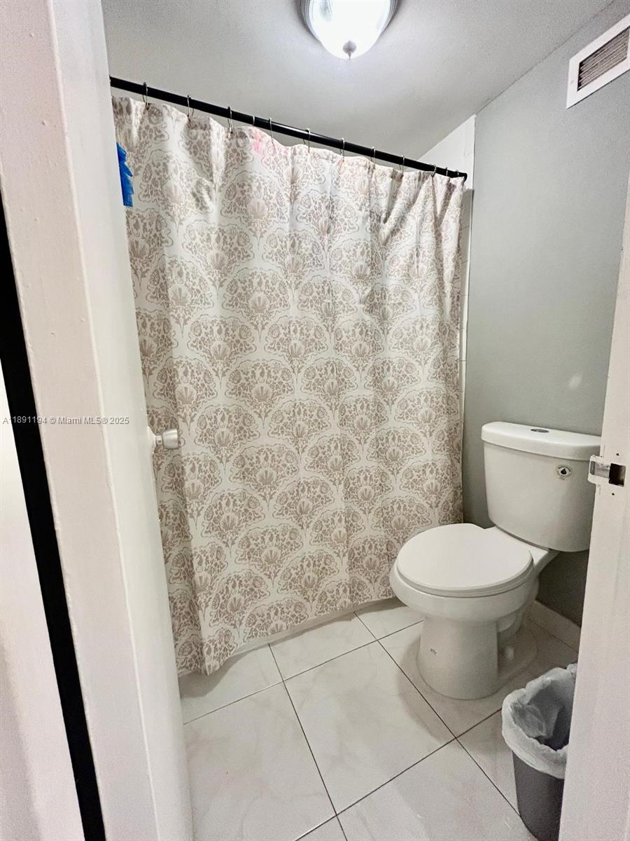 100 Lincoln Road, Unit 1616 Miami Beach, FL 33139 - Photo 5 of 7 a bathroom with a toilet and a shower curtain