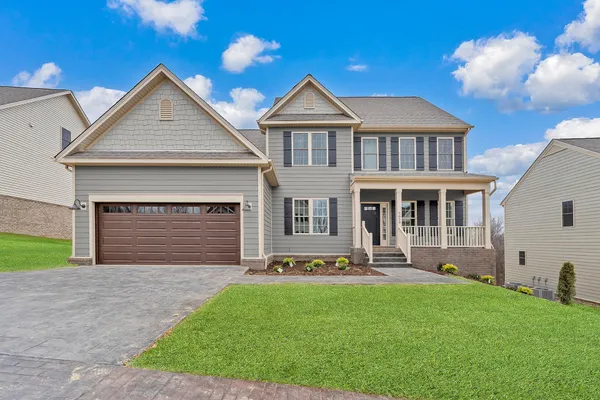 a front view of a house with a yard and garage