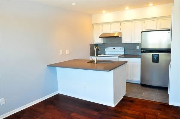 a room with wooden floor and electronic appliances