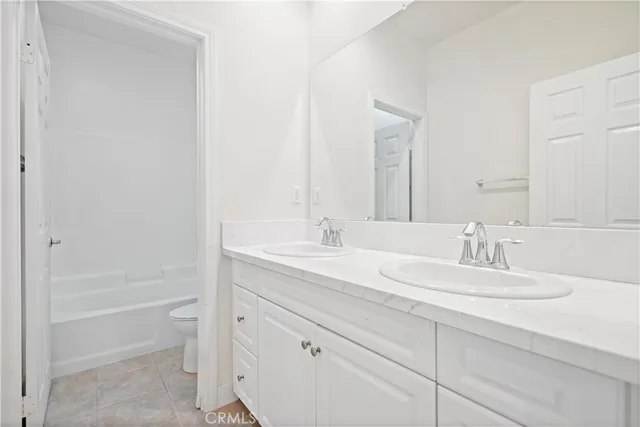 a bathroom with a granite countertop toilet a sink and a bathtub