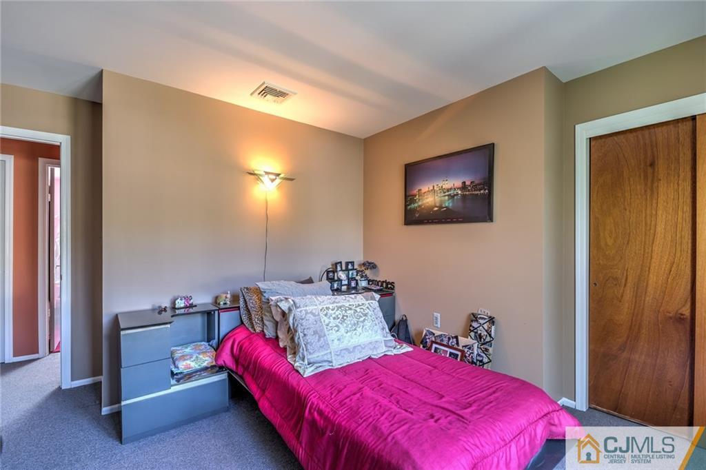 12 Higgins Road Old Bridge, NJ 08857 - Photo 17 of 25 a bedroom with a bed and a lamp with the walls