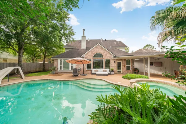 a front view of a house with swimming pool having outdoor seating