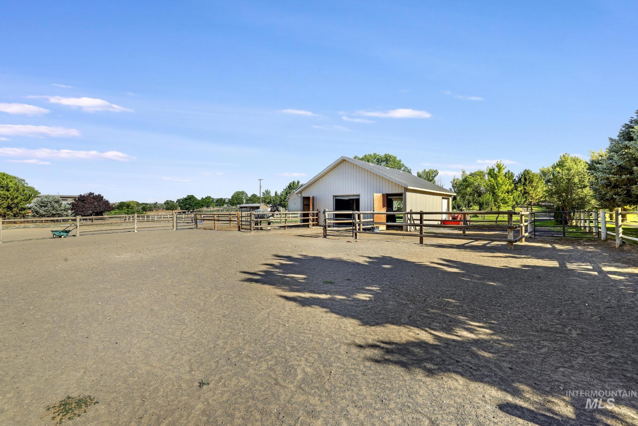 1301 Kanaka Rapids Road Buhl, ID 83316 - Photo 46 of 50 Expansive outdoor arena featuring a light-colored ground surface, perimeter fencing, and a white barn with a dark roof