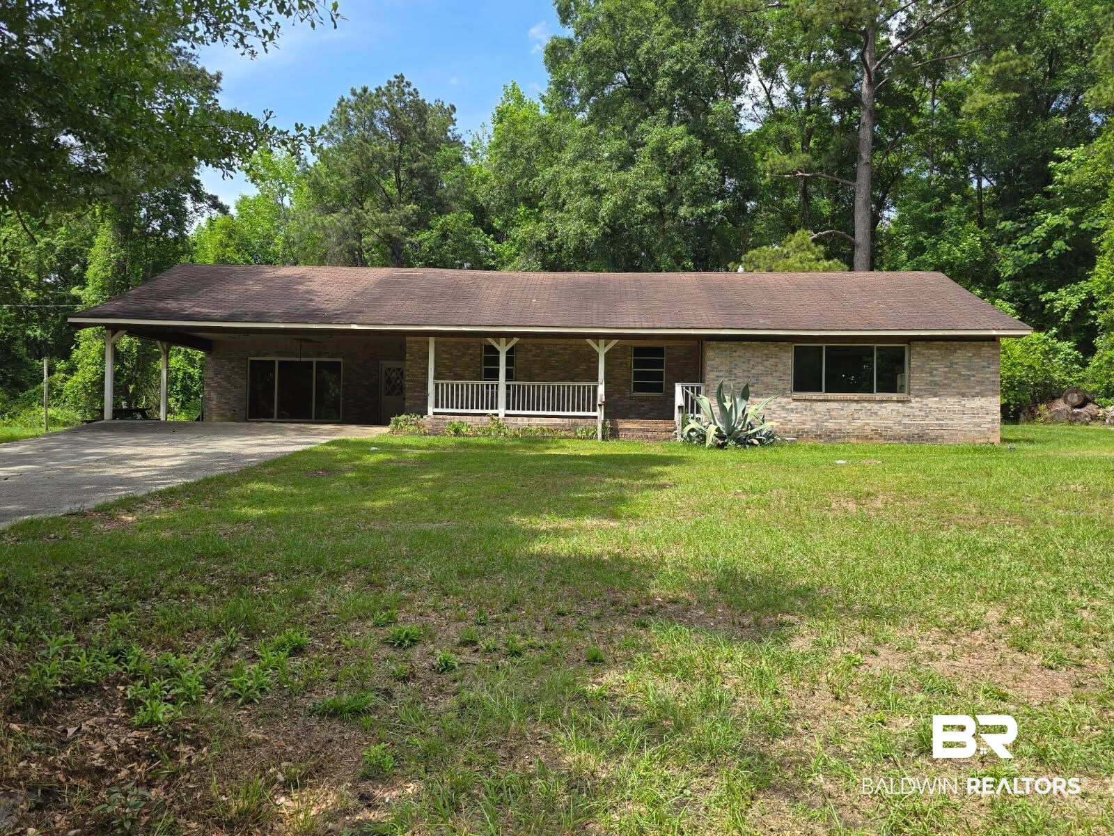 4072 Appleton Road Brewton, AL 36426 - Photo 1 of 7 Ranch-style home featuring a porch, an attached carport, concrete driveway, and a front yard