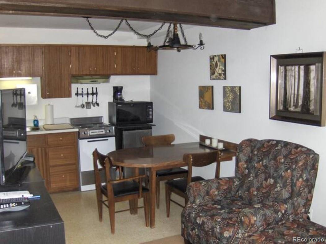 2469 Chamonix Lane, Unit E4 Vail, CO 81657 - Photo 13 of 24 a kitchen with stainless steel appliances granite countertop a stove top oven a sink a dining table and chairs