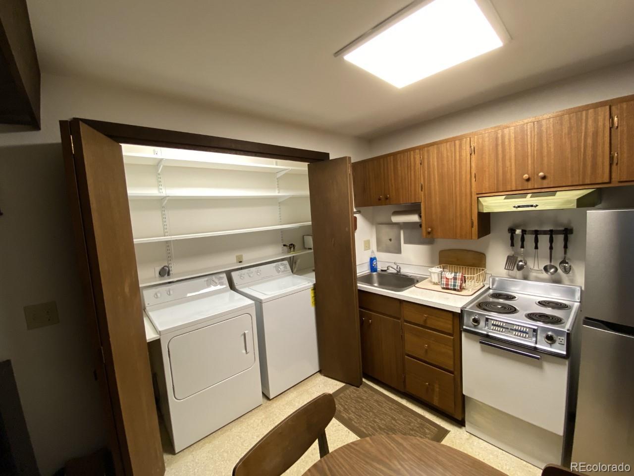 2469 Chamonix Lane, Unit E4 Vail, CO 81657 - Photo 14 of 24 a kitchen with granite countertop a sink stove and cabinets