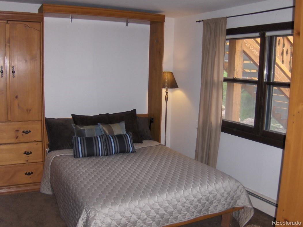 2469 Chamonix Lane, Unit E4 Vail, CO 81657 - Photo 16 of 24 a bedroom with a bed and a large window