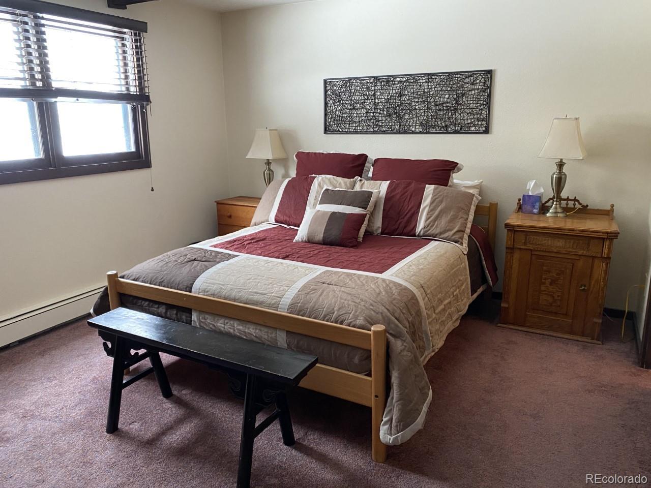 2469 Chamonix Lane, Unit E4 Vail, CO 81657 - Photo 9 of 24 a bed sitting in a bedroom next to a window