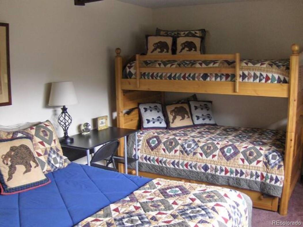 2469 Chamonix Lane, Unit E4 Vail, CO 81657 - Photo 10 of 24 a bedroom with a bed and a lamp on dresser