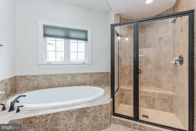 a white bath tub sitting next to a shower