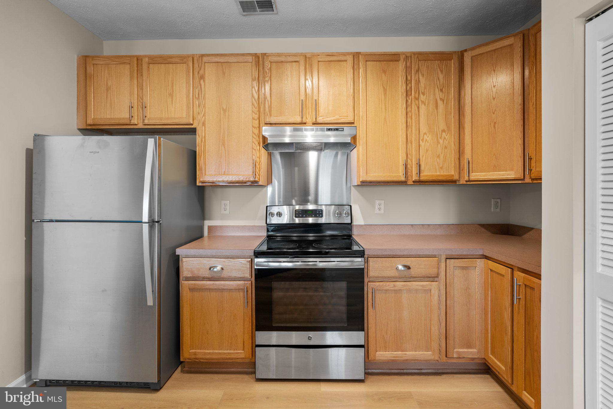 5458 Glenthorne Court, Unit 5458 Baltimore, MD 21237 - Photo 13 of 32 a kitchen with a stove and a refrigerator