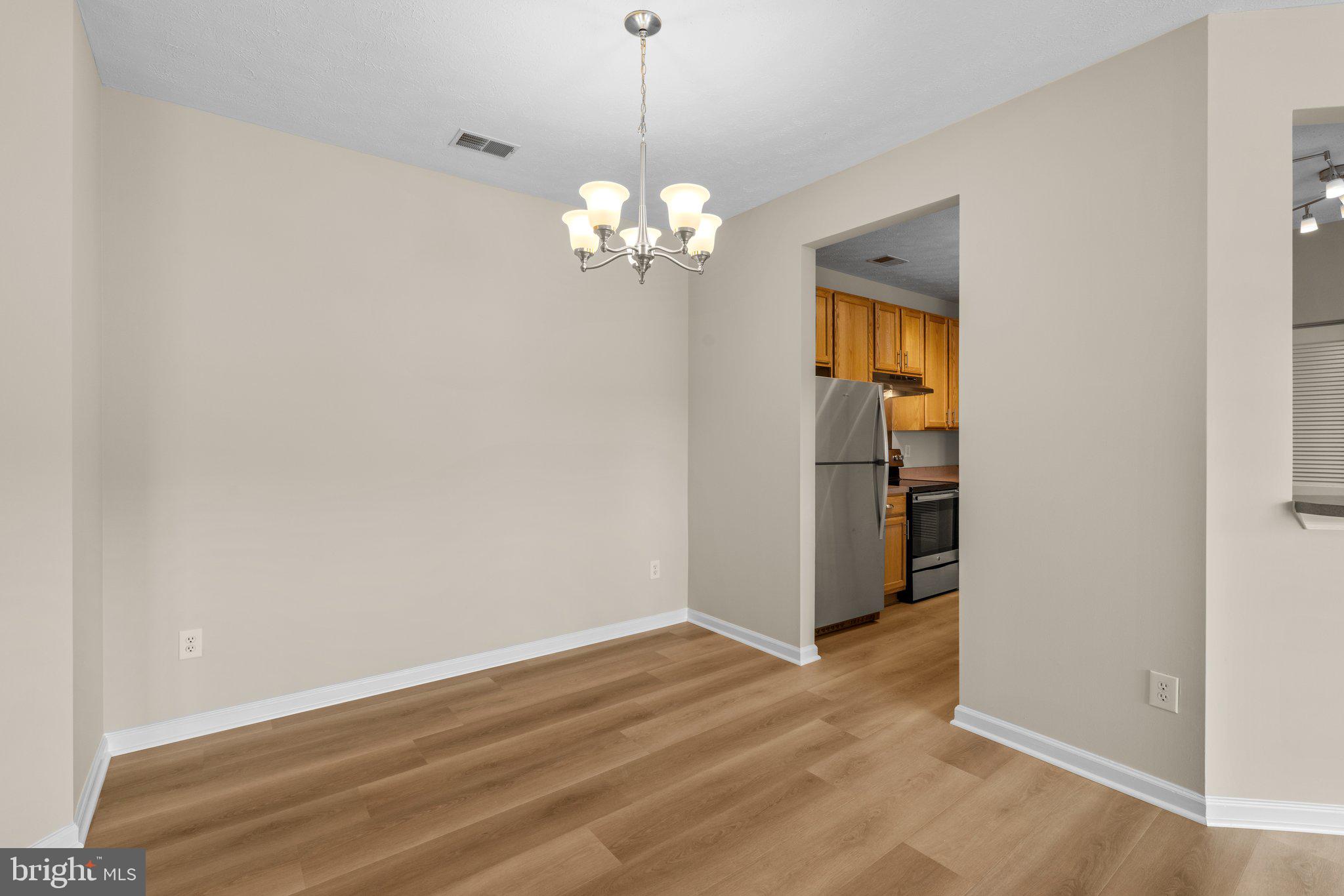 5458 Glenthorne Court, Unit 5458 Baltimore, MD 21237 - Photo 6 of 32 a view of a chandelier fan and a refrigerator in a room