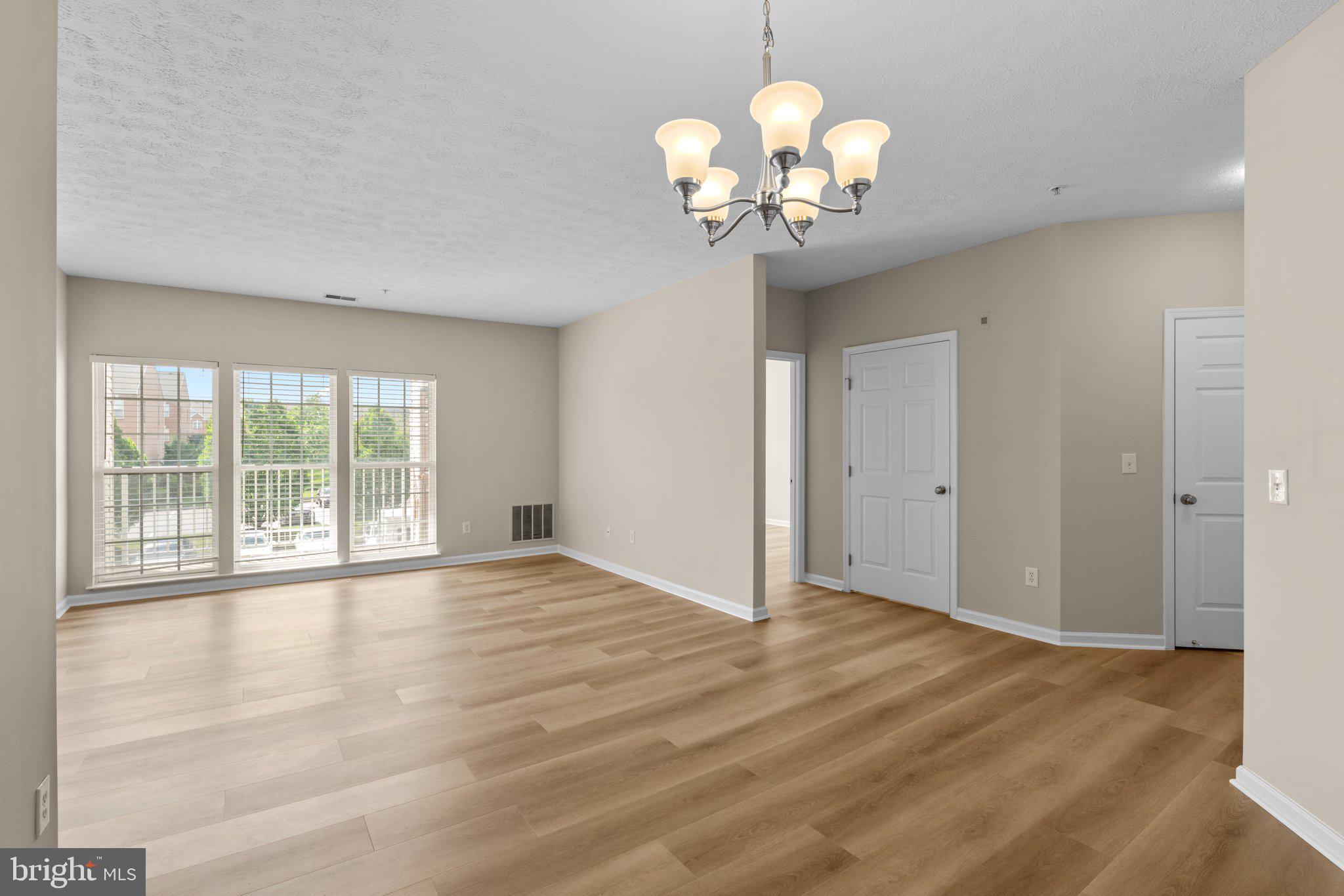 5458 Glenthorne Court, Unit 5458 Baltimore, MD 21237 - Photo 9 of 32 a view of an empty room with a chandelier and wooden floor
