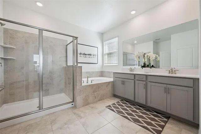 a spacious bathroom with a shower sink and mirror
