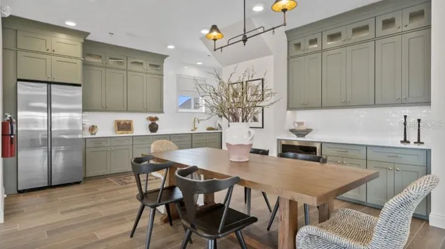 a kitchen with granite countertop a table chairs a sink dishwasher refrigerator and microwave