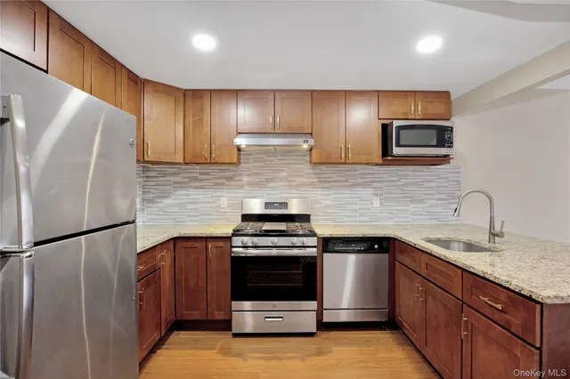 a kitchen with stainless steel appliances granite countertop a stove a refrigerator and a sink