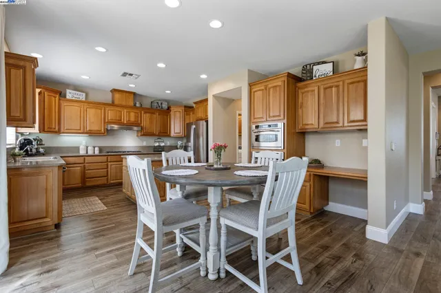 a kitchen with stainless steel appliances granite countertop a refrigerator a sink and a stove