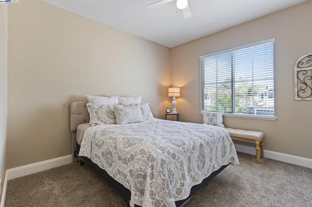 a spacious bedroom with a large bed and a chandelier