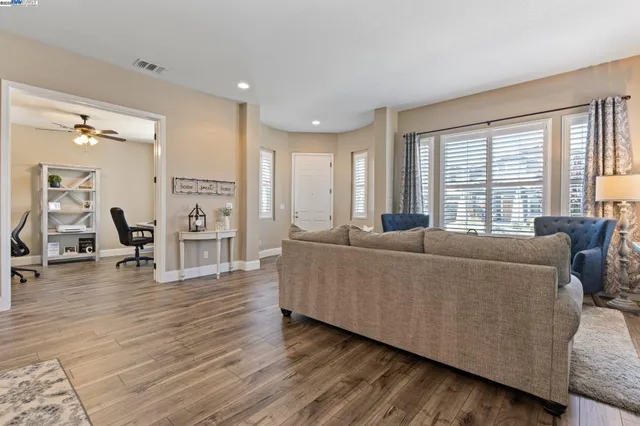 a dining room with wooden floor a chandelier a wooden table and chairs