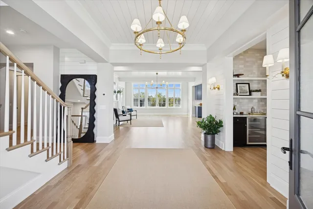 a view of a hallway with wooden floor and a chandelier