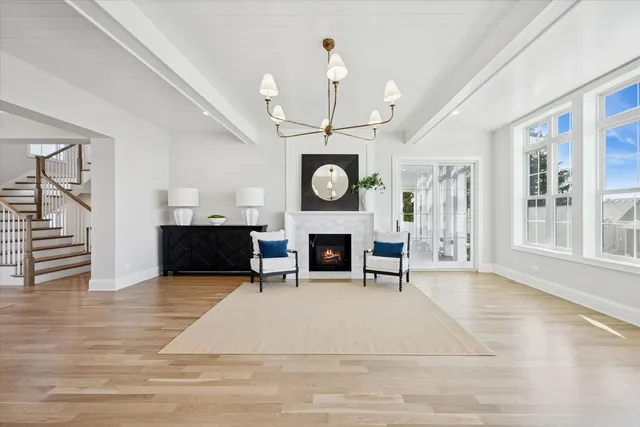 a living room with furniture a fireplace and a chandelier