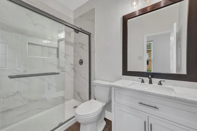 an empty room with wooden floor and ceiling fan