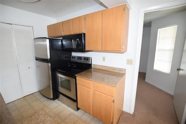 a kitchen with granite countertop stainless steel appliances and white cabinets