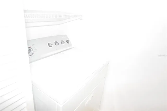 a utility room with a bed and a microwave