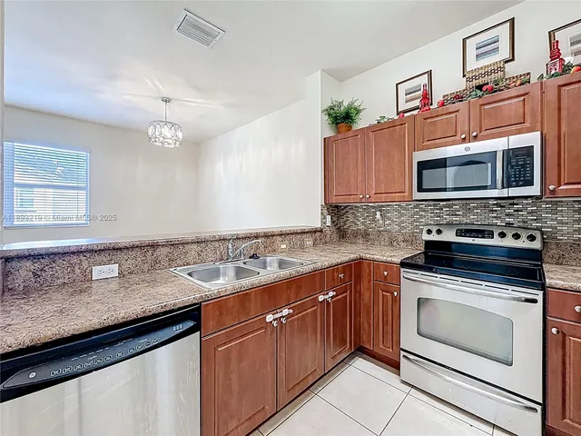 a kitchen with stainless steel appliances granite countertop a sink stove and microwave
