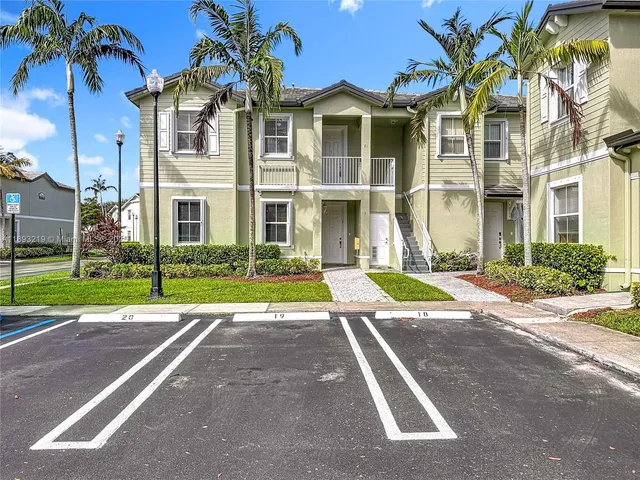 a view of a white house with a yard next to a road