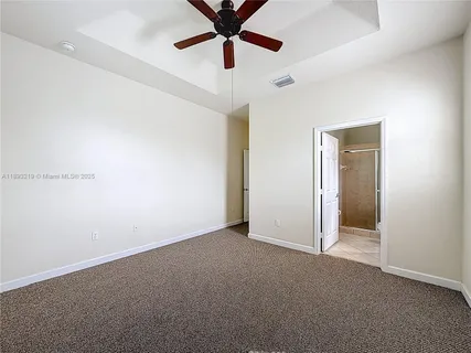 an empty room with closet and a chandelier fan